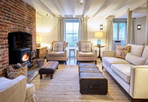 a living room with a couch and a fireplace at Grints Cottage in Burnham Thorpe