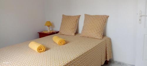 a bedroom with a bed with two pillows on it at Logement d'affaires et de séjours de groupes du Robert in Le Robert