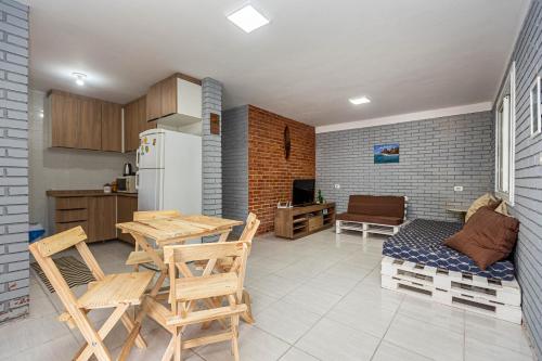 a kitchen and dining room with a table and chairs at Memora Guesthouse Pontal do Paraná - Casa inteira ou Quartos a duas quadras da praia e próxima a Ilha do Mel in Pontal do Paraná