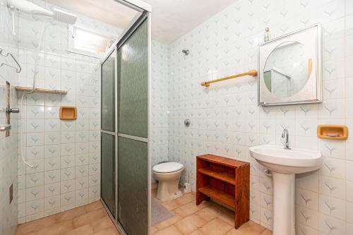 a bathroom with a shower and a sink and a toilet at Memora Guesthouse Pontal do Paraná - Casa inteira ou Quartos a duas quadras da praia e próxima a Ilha do Mel in Pontal do Paraná