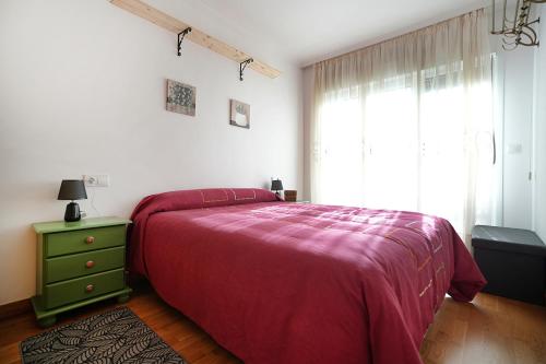 a bedroom with a bed and a green dresser and a window at GALIHOST - Apartamento con terraza en Barrantes in Ribadumia