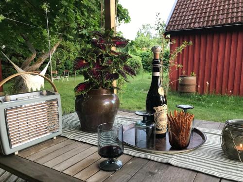 a table with a bottle of wine and a plant at Hus i Heda in Ödeshög