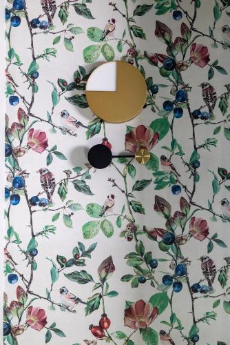 a mirror on a wall with a floral wallpaper at Hotel L de Lutece - Notre-Dame in Paris