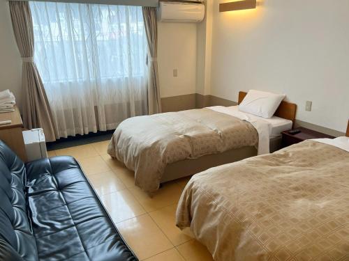 a hotel room with two beds and a couch at Hotel Yamadaso - Vacation STAY 41344v in Nago