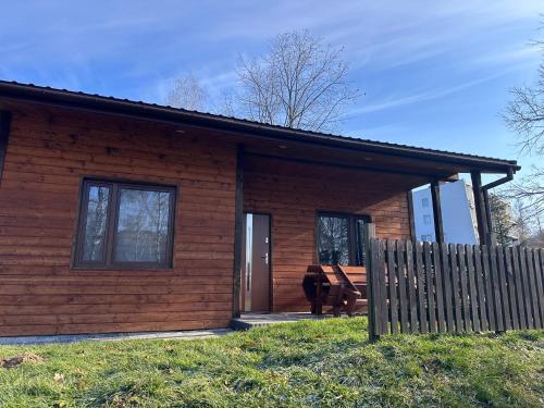 a log cabin with a bench in front of it at Ośrodek Ustronie w Myczkowcach in Myczkowce