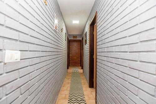 a hallway with a brick wall at Memora Guesthouse Pontal do Paraná - Casa inteira ou Quartos a duas quadras da praia e próxima a Ilha do Mel in Pontal do Paraná
