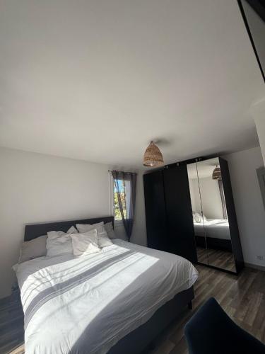 une chambre avec un grand lit et un miroir dans l'établissement Maison moderne avec piscine, à Sanary-sur-Mer