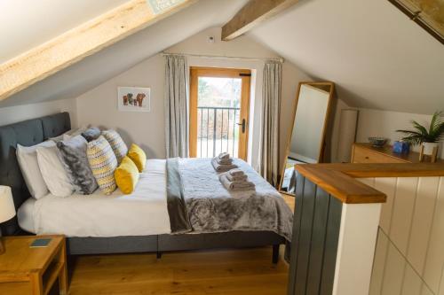 a bedroom with a bed with pillows and a window at Cedar Cottage in Eckington