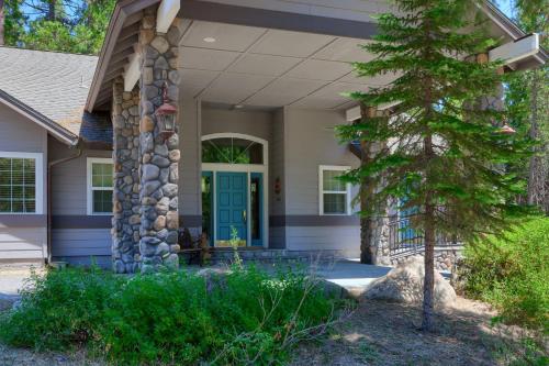a house with a blue door and a pine tree at The Terry Cabin in Wawona