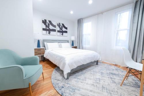 ブルックリンにある323-1 Spacious 2BR Williamsburgの白いベッドルーム(ベッド1台、青い椅子付)