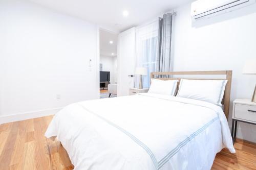 ブルックリンにある323-1 Spacious 2BR Williamsburgの白いベッドルーム(白い枕の白いベッド付)