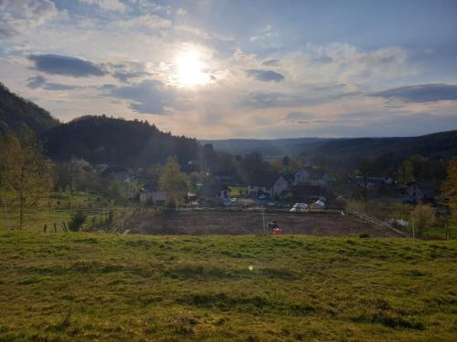 a view of a field with the sun in the sky at Chevaux au Soleil in Fresse