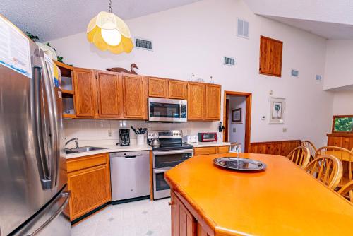 a kitchen with wooden cabinets and a stainless steel refrigerator at Christie in Duck
