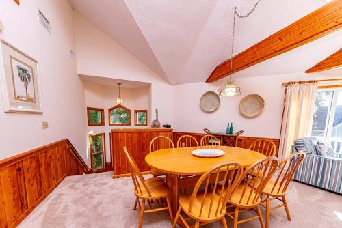 a dining room with a wooden table and chairs at Christie in Duck