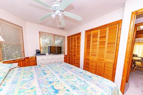 a bedroom with a bed and a ceiling fan at Christie in Duck