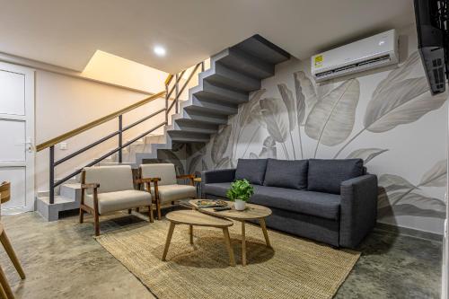 a living room with a couch and a staircase at Apartamento De La Cruz Con Rooftop By SoHo in Cartagena de Indias
