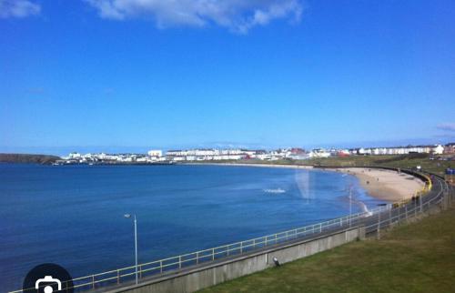 - une vue sur une plage à côté d'un pont dans l'établissement Relax at the Golf, à Portrush