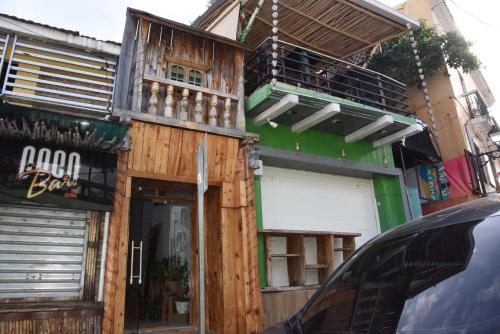 a wooden building with a balcony on the side of it at Hostel Gato Colonial in Santo Domingo