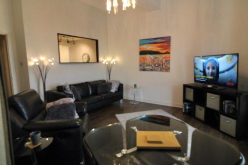 a living room with a couch and a tv at Ayr Apartment with Sea and Countryside views in Ayr