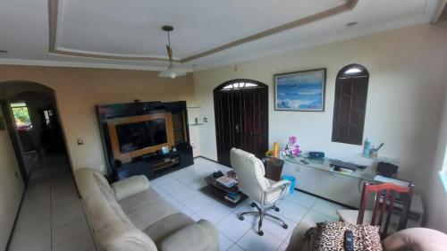 a living room with two white couches and a desk at Casa Ilha de Vera Cruz - Bahia in Vera Cruz de Itaparica
