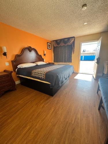 a bedroom with a bed with an orange wall at Walden Motel in Las Vegas