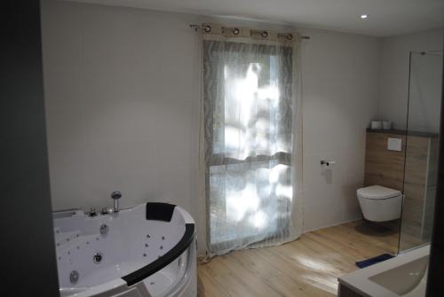 une salle de bain avec baignoire et toilettes dans l'établissement Villa La Bertine Haute, à Saillac