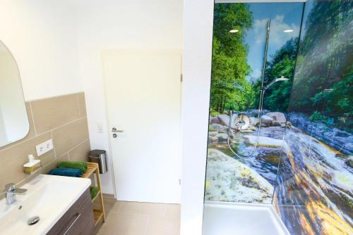 a bathroom with a shower with a painting on the wall at Murg im Schwarzwaldhäusle in Freudenstadt