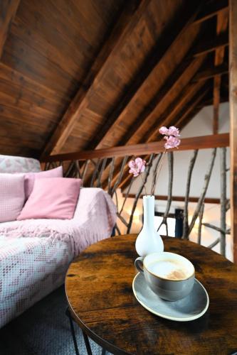 a coffee table with a cup of coffee and a vase at Pension Kleiner König in Struppen-Siedlung