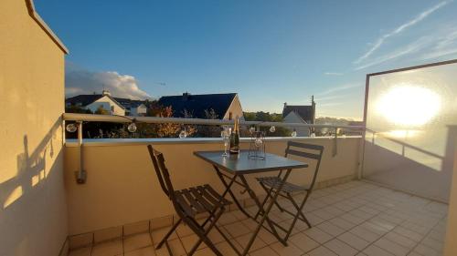 a small balcony with a table and chairs on it at Au Clair De Lune in Pléneuf-Val-André