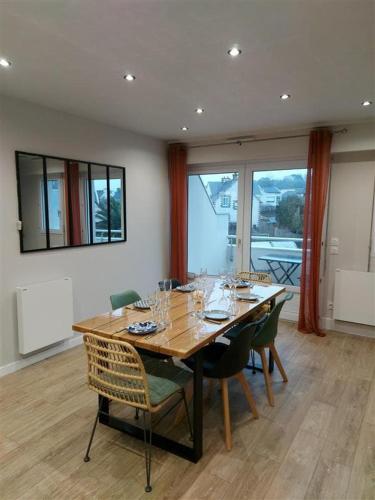 a dining room with a wooden table and chairs at Au Clair De Lune in Pléneuf-Val-André