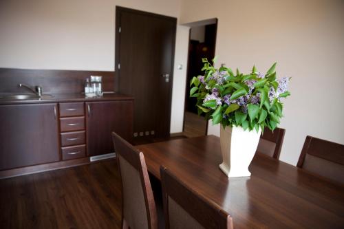 a dining room table with a vase of flowers on it at Sanatorium Budowlani Szczawnica in Szczawnica