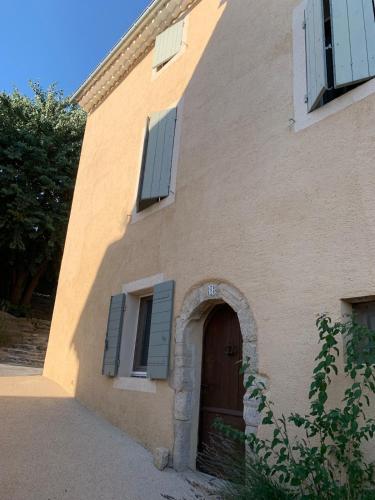un bâtiment avec une porte et des fenêtres marron dans l'établissement Grande maison de village - solarium et terrasse, à Saint-Martin-de-Castillon