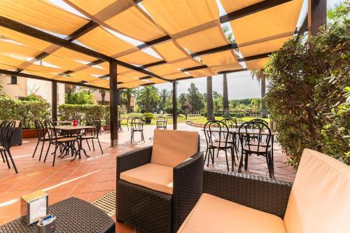 an outdoor patio with tables and chairs and a table at Classical Res Baia Delle Palme Prem Bilo 4 person in Santa Margherita di Pula
