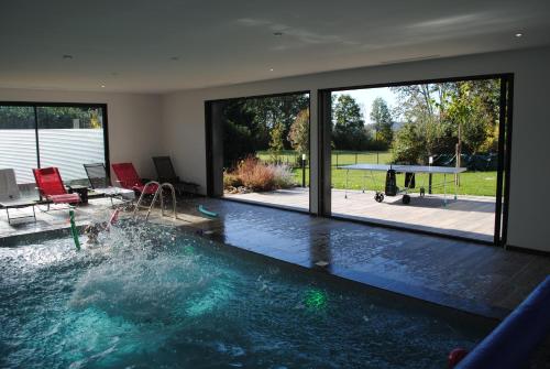 - une piscine dans une maison avec une grande fenêtre dans l'établissement Villa La Bertine Haute, à Saillac
