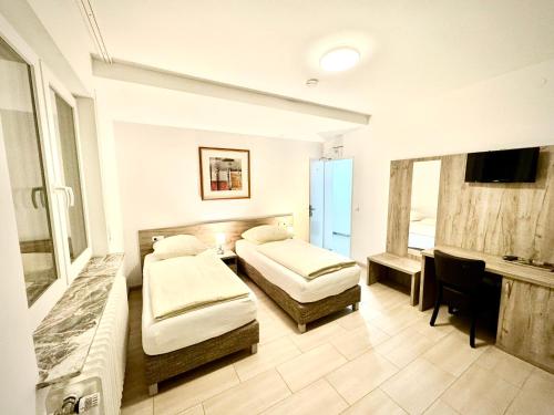 a hotel room with two beds and a television at Hotel Soad in Salach