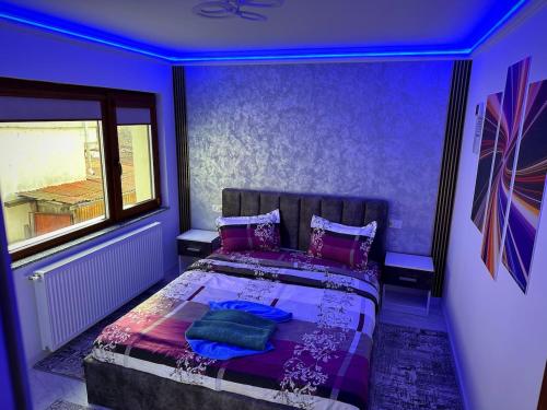 a purple bedroom with a bed with a window at Apartament cu 2 Dormitoare de lux situat in complex ApartHotel Botosani 4 in Botoşani