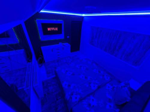 a dark room with a bed and a blue light at Apartament cu 2 Dormitoare de lux situat in complex ApartHotel Botosani 4 in Botoşani