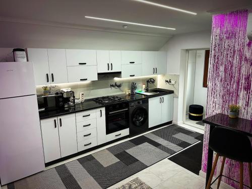 a kitchen with white cabinets and a dishwasher at Apartament cu 2 Dormitoare de lux situat in complex ApartHotel Botosani 4 in Botoşani