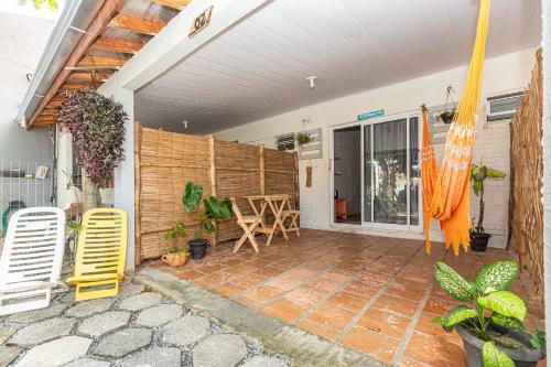 a patio with two chairs and a wooden wall at Memora Guesthouse Pontal do Paraná - Suíte a duas quadras da Praia e perto da Ilha do Mel in Pontal do Paraná