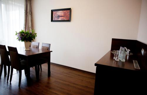 a dining room with a table with chairs and a plant at Sanatorium Budowlani Szczawnica in Szczawnica