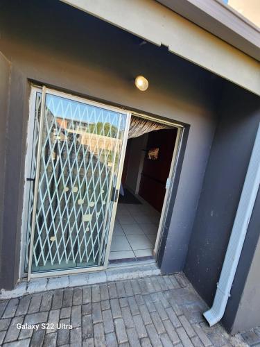 an open door with a gate in a house at Wampex Guest House in Rustenburg