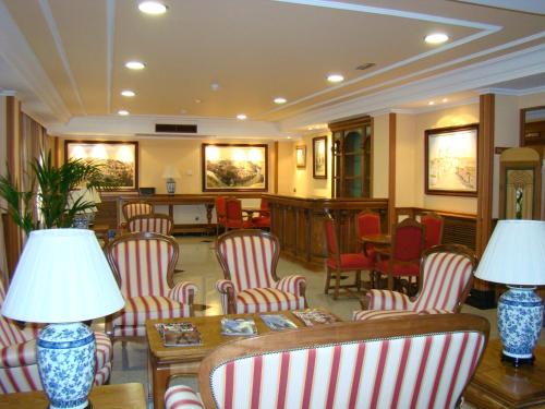 a lobby with red and white chairs and lamps at Hotel II Castillas Ávila in Ávila