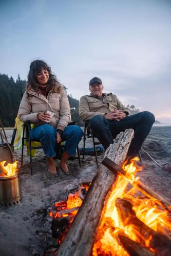 a couple of people sitting around a fire at Salt Hotel & Pub in Ilwaco