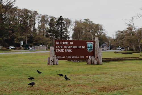 a sign for a park with birds standing around it at Salt Hotel & Pub in Ilwaco