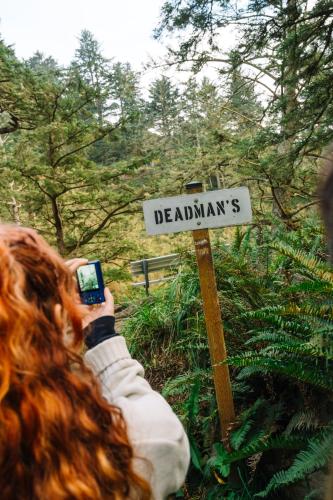 a woman taking a picture of a sign with her phone at Salt Hotel & Pub in Ilwaco