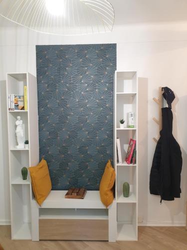 a shelf with yellow pillows and a wall at Double-studio 4p Calme 100m métro idéal Séjour Maison examens in Cachan