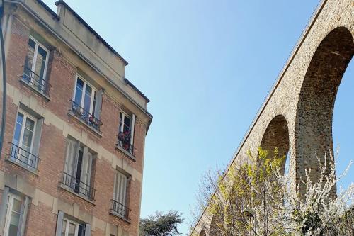 a tall brick building next to a tall building at Double-studio 4p Calme 100m métro idéal Séjour Maison examens in Cachan