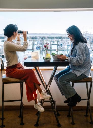 a woman taking a picture of another woman sitting at a table at Salt Hotel & Pub in Ilwaco