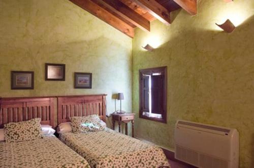 a bedroom with two beds and a window at Casa Rural Vallehermoso in San Carlos del Valle