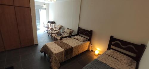 a bedroom with two beds and a table and chairs at Economical Hosting Downtown - Hospedagem econômica no centro de Campinas in Campinas